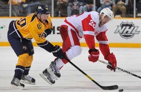 Ryan Ellis #49 of the Nashville Predators checks Drew Miller #20 of the Detroit Red Wings during an NHL game at the Bridgestone Arena on December 26, 2011 in Nashville, Tennessee. (Photo by John Russell/NHLI via Getty Images)