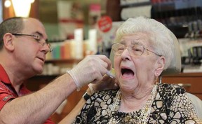 WINDSOR, ONTARIO -JANUARY 18, 2012 - 101 year-old Viola Arnold grimaces while having her ears pierced by Caryl Baker Visage Cosmetics owner Ken Gayowsky at Devonshire Mall in Windsor, Ontario on January 18, 2012. SEE STORY BY SHARON HILL . (JASON KRYK/ The Windsor Star)
