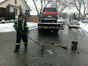 Shawn Birston of Myers Towing cleans up following a collision at Goyeau and Shepherd Streets in Windsor on Jan. 30, 2012. (Photo By: Nick Brancaccio)