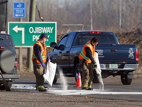 Windsor firefighters spread absorbent on the roadway of Ojibway Parkway near Broadway Blvd. following a three-vehicle collision involving a Jeep CJ, Ford Windstar minivan and a Dodge Caravan January 10, 2012. (NICK BRANCACCIO/The Windsor Star)