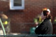 A resident at 7251 St. Rose avenue watches as Windsor firefighters inspect the rear of her house after it caught fire, Friday, January 6, 2012. (DAX MELMER/The Windsor Star)