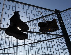 Workers boots hang on the fence surrounding the Electro-Motive Canada plant in London, Ontario on February 13, 2012. (Photo By: Jason Kryk)
