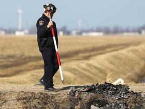 A Chatham-Kent police officer conducts an investigation at the scene of a single vehicle collision that left two people dead and one severely injured on Coatsworth Road and Herman Line in Tilbury East, Sunday, Feb. 5, 2012. (Dax Melmer/The Windsor Star)