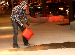 Windsor, Ontario. February 4, 2012.  A man pours a bucket of water on drops of blood on the sidewalk from a man who fell from the second floor level of a downtown hotel late Sat. Feb. 4, 2012.  The man sustained injuries to his head and was taken to hospital by ambulance. (REBECCA WRIGHT/The Windsor Star)