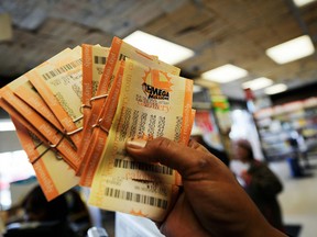 A hopeful customer holds up a handful of newly purchased Mega Millions tickets at a Hawthorne, California convenience store on Mar. 29, 2012.