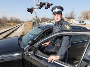 Ontario Provincial Police Const. Blake Cohoe poses Tuesday, Mar. 6, 2012, near the Via Rail tracks on Emery Dr. in Emeryville, Ont. Cohoe blocked the tracks with his cruiser early this morning to alert an oncoming train to a car that was struck on the tracks. (Dan Janisse/The Windsor Star)