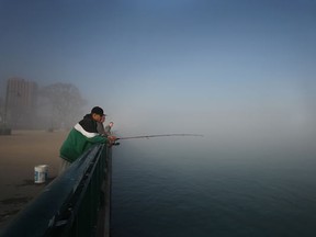 From left, Troy Shaw, Walter Szymanski, and Rick Stenkiwicz fish at the Windsor riverfront in downtown Windsor as a blanket of fog covers the Detroit River early Saturday morning, Saturday, Mar. 17, 2012. (DAX MELMER/The Windsor Star)