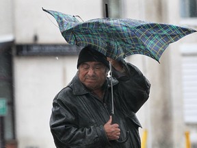 In this file photo, Jose Basquez wrestles with an umbrella in windy conditions. (Dan Janisse/The Windsor Star)
