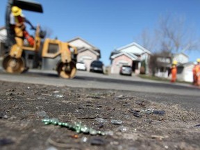 LONDON, ONT. -- In this file photo, shattered glass and remnants of St. Patrick's Day celebrations scatter Fleming Drive in London, Ont. where a mob of 1,000 flipped a news truck and caused about $100,000 of damage. Municipal crews had to repair a section of the residential of the road which had been scarred by the fire and had shards of debris melted in the pavement. (DYLAN KRISTY/The Windsor Star)