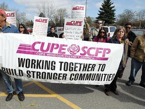 Protesters hold signs during a protest outside of the offices of Dwight Duncan, Ontario Finance Minister, in Windsor on Monday, March 26, 2012. CUPE and other unions staged the protest ahead of Tuesday's provincial budget.(TYLER BROWNBRIDGE/The Windsor Star)