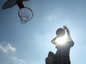 Grade 7 student Justin Johnston, 13, takes advantage of the warm weather with some basketball at Hugh Beaton Public School on Mar. 13, 2012.