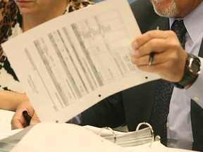 The hands of city solicitor George Wilkki pick over documents in this March 2007 file photo.