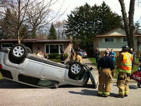 Firefighters look over an upside-down vehicle at 4240 Longfellow Ave. in Windsor, Ont. on March 19, 2012. An 85-year-old male driver was removed from the wreck and taken to hospital.