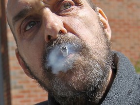 Cancer patient Kim Berry, 60, smokes on the Met Campus of Windsor Regional Hospital on Mar. 26, 2012.