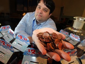 Ron Dunn of the Windsor Downtown Mission holds up a handful of pennies. The mission has launched a campaign asking the public to donate unwanted pennies. (Nick Brancaccio / The Windsor Star)