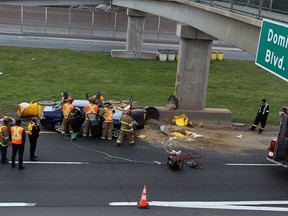 Firefighters and paramedics work to free a woman from the wreckage of a Ford sedan that crashed on the E.C. Row Expressway near Dominion Boulevard in Windsor, Ont. on April 5, 2012. (Nick Brancaccio / The Windsor Star)