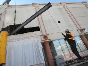 Workers move a large piece of steel into place Tuesday, April 17, 2012, in Windsor, Ont. at the former Palace Theatre on Ouellette Ave., the future home of the Windsor Star. The steel will be used to build up the floors in the building. (DAN JANISSE/The Windsor Star)
