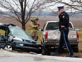 Sgt. Phil Ouellette, right, from the Ontario Provincial Police, investigates the scene of a two-car motor vehicle collision involving a Honda Acura and a Chevy pick-up at the intersection of Walker Road and South Talbot Road in Tecumseh, Saturday, Dec. 31, 2011. (Photo By: Dax Melmer)