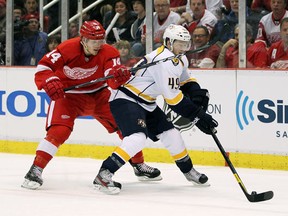 Ryan Ellis #49 of the Nashville Predators tries to control the puck in front of Gustav Nyquist #14 of the Detroit Red Wings in the first period during Game Three of the Western Conference Quarterfinals during the 2012 NHL Stanley Cup Playoffs at Joe Louis Arena on April 15, 2012 in Detroit, Michigan. (Photo by Gregory Shamus/Getty Images)