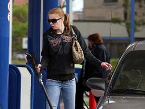 Danielle Lauzon fills up her car at the Mac's gas station at Erie Street and Ouellette Avenue in Windsor, Ont. on Tuesday, April 3, 2012.