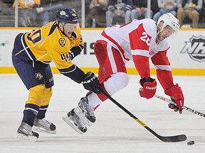 Ryan Ellis #49 of the Nashville Predators checks Drew Miller #20 of the Detroit Red Wings during an NHL game at the Bridgestone Arena on December 26, 2011 in Nashville, Tennessee. (Photo by John Russell/NHLI via Getty Images)