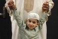Kaab Shujah, a three-year-old Windsor Muslim, hangs onto his father's hands at the WFCU Centre in this August 2011 file photo. (Dax Melmer / The Windsor Star)