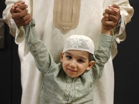 Kaab Shujah, a three-year-old Windsor Muslim, hangs onto his father's hands at the WFCU Centre in this August 2011 file photo. (Dax Melmer / The Windsor Star)