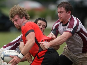 Rugby players Mike Park (L) and Eric Cochrane (R) tangle on Windsor's AKO field in this July 2011 file photo. (Dax Melmer / The Windsor Star)