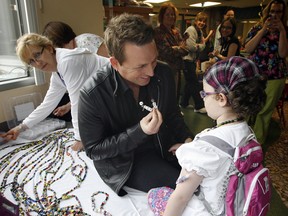 Country music artist Johnny Reid charms Bridgid Kidd in the pediatrics unit of Windsor Regional Hospital's Met Campus on May 4, 2012. (Nick Brancaccio / The Windsor Star)