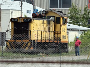 Ed Dunn from Ed Dunn auctions at the old General Chemical/ Honeywell plant in Amherstburg stands next to a locomotive up for auction, in preparation for Saturday's auction.