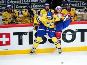 Sweden's Henrik Zetterberg (L) body checks Norway's Mathis Olimb during a preliminary round match at the Ice Hockey World Championships in Stockholm on May 4, 2012. Sweden won 3-1. (JONATHAN NACKSTRAND/AFP/GettyImages)