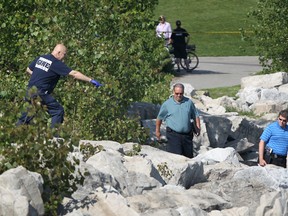 A Windsor firefighter points out to police detectives the scene where a woman's body was found on the downtown riverfront on the morning of May 20, 2012. Police have released the identity of the woman as 59-year-old downtown resident Patricia Morencie. (Dax Melmer / The Windsor Star)