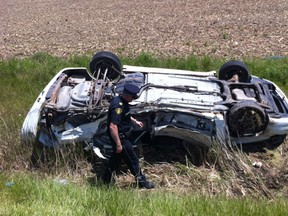 An OPP officer checks a flipped car after a two-vehicle crash on Manning Road near County Road 46 on May 18, 2012. (Dan Janisse / The Windsor Star)
