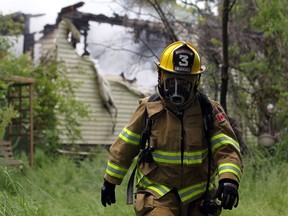 A masked firefighter works at the scene of a house fire in the 500 block of Patillo Road in Lakeshore, Ont. on May 22, 2012. (Dax Melmer / The Windsor Star)