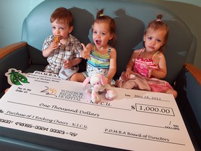 21-month-old triplets Nathan (L), Ellie (C) and Autumn Bensette (R) sit with a cheque donated by the Parents of Multiple Births Association to equip the NICU at Windsor Regional Hospital's Met Campus with new rocking chairs. Photographed May 28, 2012. (Nick Brancaccio / The Windsor Star)