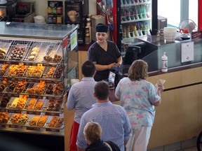Maria Coccimiglio serves customers Thursday at the Tim Horton's kiosk in the lobby of Windsor Regional Hospital.