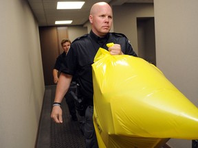 A police officer removes a package containg a human foot from the Conservative Party headquarters in Ottawa on Tuesday, May 29, 2012. THE CANADIAN PRESS/Sean Kilpatrick