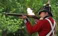 Bill Kovacs, dressed as a sgt. of the Royal Marines from 1812, fires his musket after the Noon Gun firing at King's Naval Yard Park in Amherstburg, Saturday, June 16, 2012. (DAX MELMER/The Windsor Star)