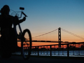 A cyclist is silhouetted as he  rides along the path at Ambassador Park in Windsor, Ontario in this file photo. (JASON KRYK/The Windsor Star)