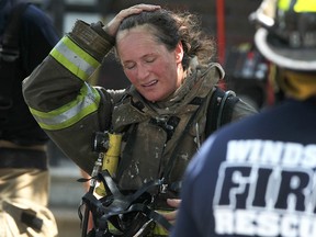 Windsor fire fighter, Sue Kipping, feels the heat while battling a fire on the 1300 block of Pillette Road, Thursday, June 28, 2012.  (DAX MELMER/The Windsor Star)