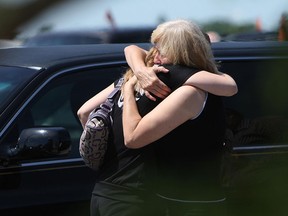 Two women hug following the funeral for Wynter Williams and Brooklyn Williams at Visitation Parish near Belle River on Saturday, June 23, 2012. The two children were killed when the minivan they were riding in was struck by a train. (The Windsor Star / TYLER BROWNBRIDGE)