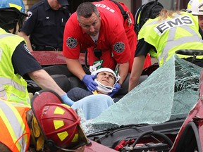 Emergency personnel work to remove a male from the wreckage of a Ford Mustang GT that smashed into a wall in the 2400 block of Tecumseh Road East. Photographed June 11, 2012. (Dan Janisse / The Windsor Star)