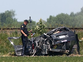 An Ontario Provincial Police officer conducts an investigation at the scene of an accident involving a minivan and a freight train on Strong Road, north of County Road 42 in Lakeshore, Ont., Sunday, June 10, 2012.   (DAX MELMER/The Windsor Star)