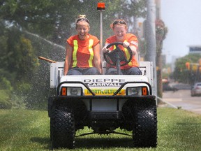 City of Windsor parks workers Courtney Lauziere (L) and Hilary Ryall (R), both 19, try to stay cool by driving through sprinklers in downtown Windsor, Ont. on June 20, 2012. (Dax Melmer / The Windsor Star)