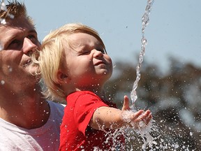 In this file photo, James Hodgson and his son Pearson, 2, get a little relief from the heat Aug. 18, 2010, at the fountain at Dieppe Gardens in downtown Windsor, Ont. (DAN JANISSE/The Windsor Star)