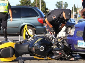 A Windsor police officer checks out a motorcycle Tuesday, July 24, 2012, that struck a car. The accident occurred on southbound Howard Ave. near the westbound EC Row on ramp. The motorcyclist suffered non-life threatening injuries. (Windsor Star / DAN JANISSE)