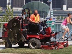 Crews cut the grass along the riverfront in Windsor on Friday, July 6, 2012. The city continues to cut the grass despite their own directive that states they won't do so on smog days. (The Windsor Star / TYLER BROWNBRIDGE)