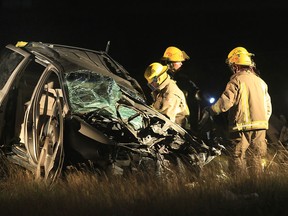 Firefighters check out a minivan involved in an accident Monday, July 23, 2012, on the 401 Highway just west of Chatham, Ont. Two people died in the van. (Windsor Star / DAN JANISSE)
