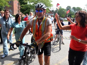 Cyclist Mike Jones, centre, arrives at Hotel-Dieu Grace Hospital in Windsor, Ont., on Tuesday, July 24, 2012, after completing a 10-week cycling trip across Canada to raise funds for HDGH cardiac catheterization lab. (NICK BRANCACCIO/The Windsor Star)