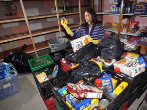 Jen Cline of the Well-Come Centre Food Bank in Windsor, Ont., sorts through damaged food which has to be thrown away following a raw sewage flood, Thursday, July 26, 2012. (NICK BRANCACCIO/The Windsor Star)
